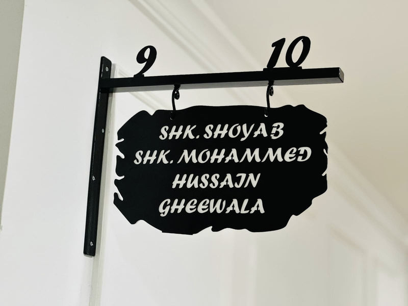 Black metal nameplate with white text on a white background